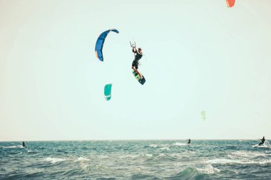 Profesyonel kiter zor hüner güzel bir arka plan üzerinde yapar. Kitesurfing Kiteboarding eylem fotoğraflar adam dalgalar arasında hızlı bir şekilde gider