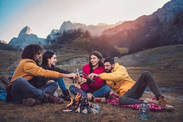 Group of young people around camp fire.