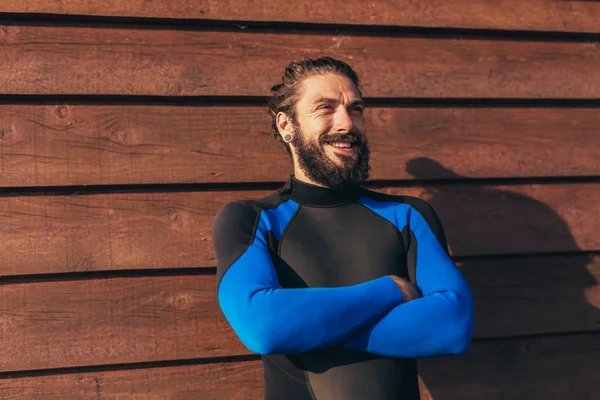 Male surfer lifestyle portrait. Man in wetsuit with bodyboard surfing equipment