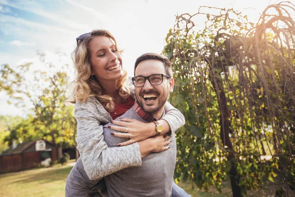 Casal Divertindo Homem Dando Piggyback Para Mulher Parque Outono — Fotografia de Stock