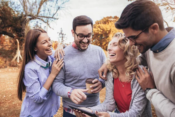 Чотири Щасливих Усміхнених Молодих Друзів Виходять Вулицю Парку Тримаючи Цифровий — стокове фото