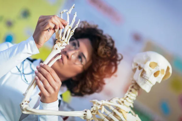 Medical doctor woman teaching anatomy using human skeleton model