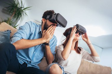 Genç erkek ve kadın sanal gerçeklik gözlük izlemek ve gösterilen rahat kıyafetler giymek Vr kamera, teknoloji ve İnovasyon kavramı düşünün