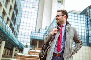 Büyük modern iş gülümseyen bina önünde duran genç işadamı