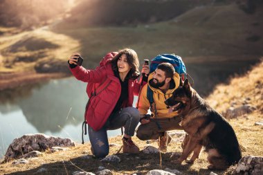 Sonbahar günü yakın göl, yapmak selfie adlı bir dağda yürüyüş yürüyüş yapan çift.