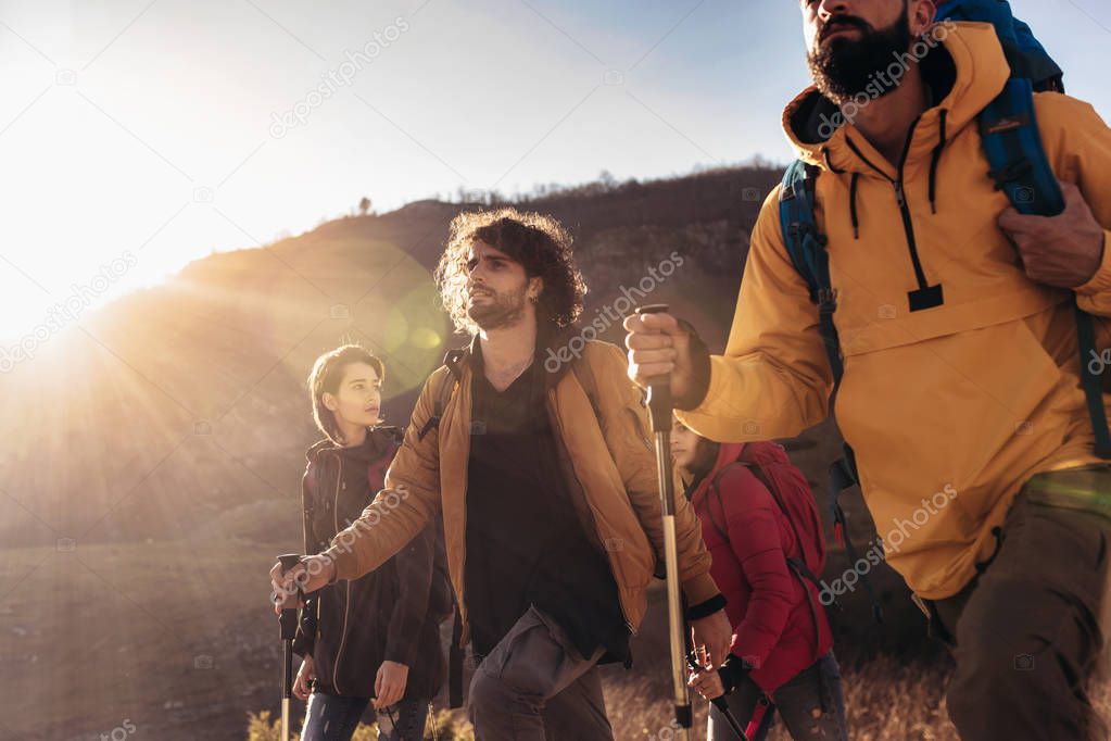 Group of hikers walking on a mountain at autumn day 