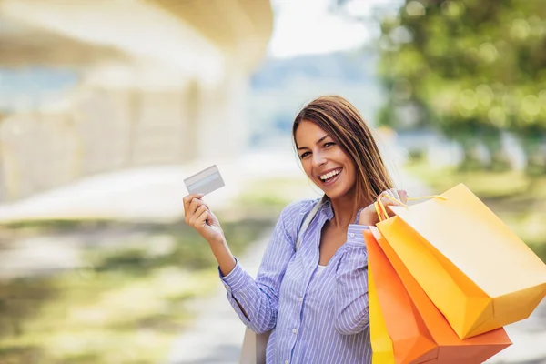 ショッピング バッグやクレジット カードを保持している若い美しい女性 — ストック写真
