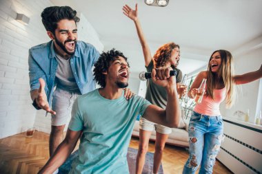 Evde karaoke yapan bir grup arkadaş. Arkadaşlık kavramı, ev eğlencesi ve insanlar