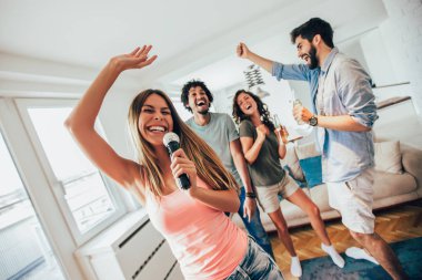 Grup arkadaşıyla evde karaoke şarkı. Kavram dostluk, ev eğlence ve insanlar hakkında