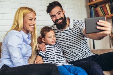 Mutlu aile dijital tablet alarak selfie evde kullanma ve having fun.