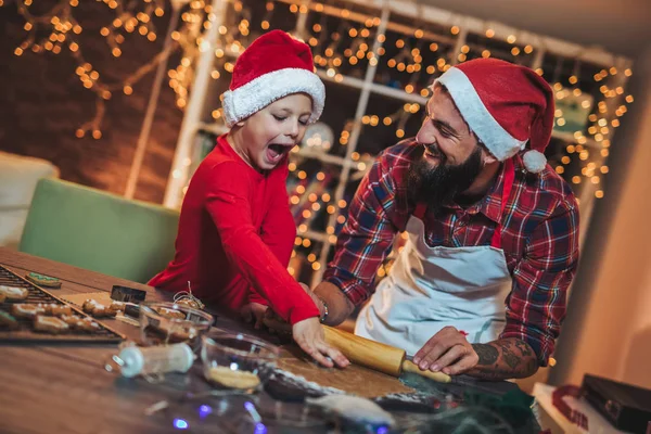 Father and son baking gingerbread Christmas cookies