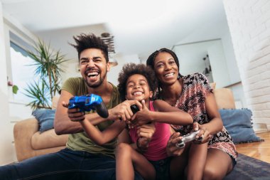 Aile birlikte video oyunları oynarken kanepede oturan gülümseyen