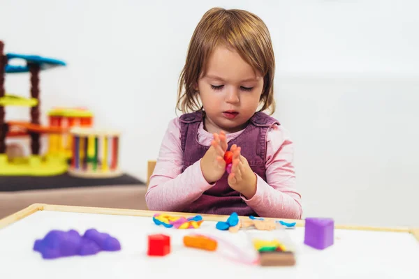 Niña Está Jugando Con Plastilina Mientras Está Sentado Mesa Habitación —  Fotos de Stock