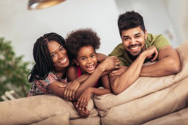 Mutlu aile evde oturma odasında kanepede birlikte poz