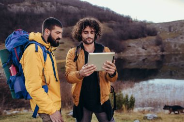 Harita üzerinden yol dijital tablet üzerinde vahşi doğada yürüyüş sırasında bakarak kayıp uzun yürüyüşe çıkan kimse