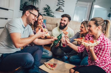 Pizza yiyen bir grup genç arkadaş. Ev partisi. Fast food konsepti..