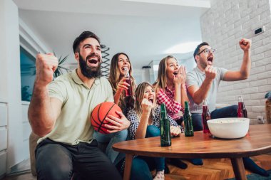 Mutlu arkadaş birlikte evde basketbol maçı izlerken