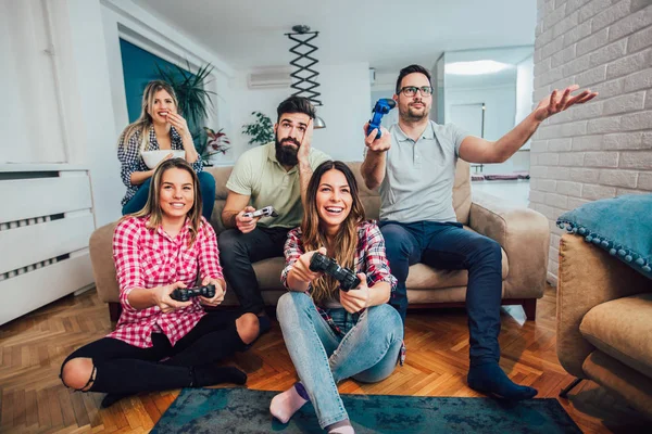 Group of friends playing video games together at home