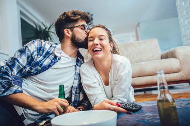 Mutlu genç çift rahatlatıcı ve evde Tv izlerken