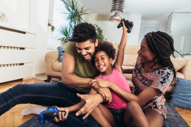 Aile birlikte video oyunları oynarken kanepede oturan gülümseyen