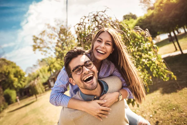 Pareja Divirtiéndose Hombre Dando Piggyback Mujer Parque — Foto de Stock