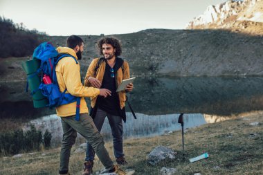 Harita üzerinden yol dijital tablet üzerinde vahşi doğada yürüyüş sırasında bakarak kayıp uzun yürüyüşe çıkan kimse
