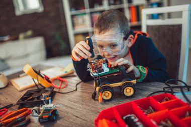 Mutlu boy gülümseyerek teknik oyuncak oluşturur. Tablo ayrıntılarını tam teknik oyuncak
