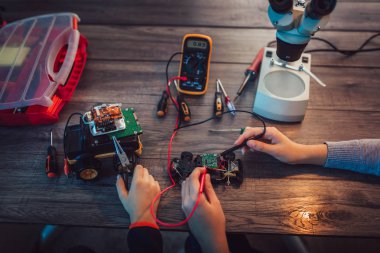 Erkek ve kız teknik oyuncak yapıları ve robot yapmak. Tablo ayrıntılarını, tam teknik oyuncak yakın çekim.