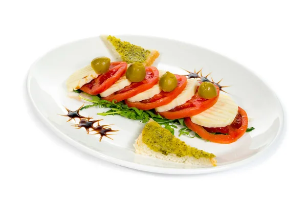 モッツァレラチーズ トマト バジルとバルサミコ酢の白いプレート上に配置のカプレーゼ サラダ — ストック写真