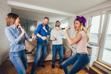 Evde karaoke yapan bir grup arkadaş. Arkadaşlık kavramı, ev eğlencesi ve insanlar