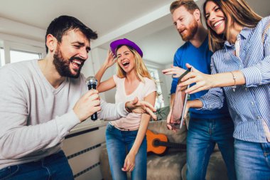Evde karaoke yapan bir grup arkadaş. Arkadaşlık kavramı, ev eğlencesi ve insanlar