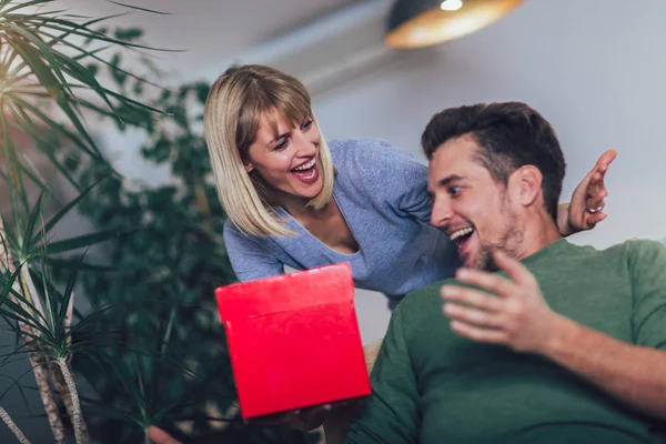 Hombre Feliz Recibiendo Regalo Novia Mientras Está Sentado Sofá — Foto de Stock