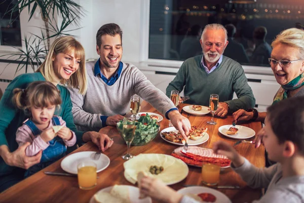 Flergenerasjonsfamilie Nyter Måltidet Rundt Bordet Hjemme – stockfoto