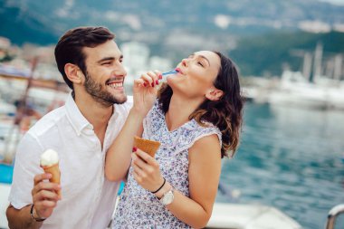 Tarihi sahip ve yemek mutlu çift tatilde dondurma. Deniz arka plan.