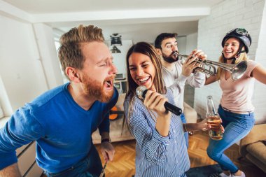 Evde karaoke yapan bir grup arkadaş. Arkadaşlık kavramı, ev eğlencesi ve insanlar