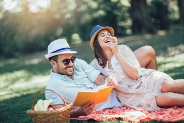 Güzel çift piknik zaman açık kitap okuma zevk