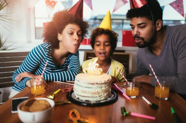 Mutlu bir aile evde doğum gününü kutluyor. 
