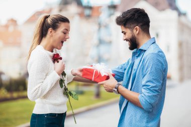 Romantik adam çiçek ve hediye kutusu kadın için Sevgililer günü için veriyor.