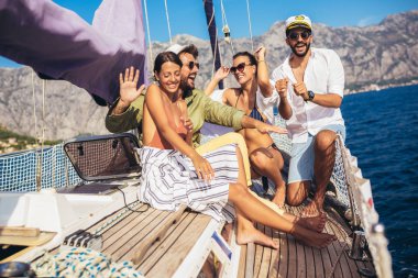 Yelkenli Yat üzerinde arkadaşları gülümseyerek. Tatil, seyahat, deniz, dostluk ve insanlar kavramı
