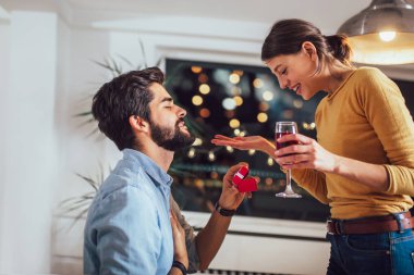 Bir kutu içinde nişan yüzüğü tutarken mutlu kız arkadaşına evlenme teklif yakışıklı bir adam portresi