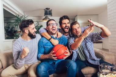 Mutlu arkadaş ya da basketbol tv ve evde zaferini kutluyor izlerken Basketbol oyunu hayranları. Dostluk, spor ve eğlence kavramı.