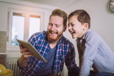 Baba ve oğul kahvaltı masasında dijital Tablet kullanma