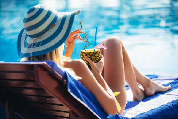 年轻妇女的画像与鸡尾酒玻璃在热带阳光附近游泳池在甲板椅子 — 图库照片