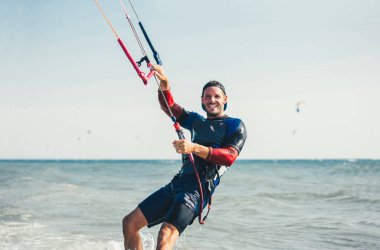 Profesyonel kiter zor hüner güzel bir arka plan üzerinde yapar. Kitesurfing Kiteboarding eylem fotoğraflar adam dalgalar arasında hızlı bir şekilde gider