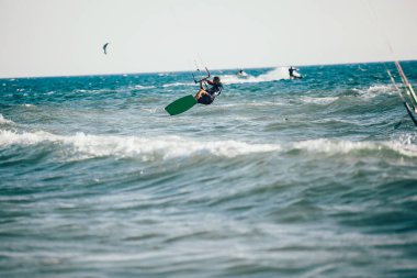 Profesyonel kiter zor hüner güzel bir arka plan üzerinde yapar. Kitesurfing Kiteboarding eylem fotoğraflar adam dalgalar arasında hızlı bir şekilde gider