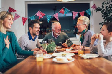 Çoklu nesil aile evde yemek masası etrafında keyfi 