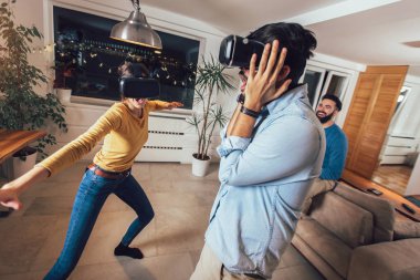 Genç çift sanal gerçeklik kulaklık gözlük - mutlu insanlar yeni eğilimleri teknoloji ile oyun oynama ile eğleniyor 