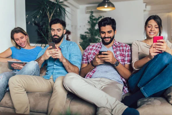 Amigos Usando Dispositivos Electrónicos Mientras Están Sentados Sofá Casa — Foto de Stock