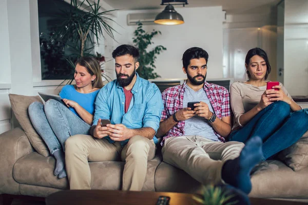Freunde Nutzen Elektronische Geräte Während Sie Hause Auf Dem Sofa — Stockfoto