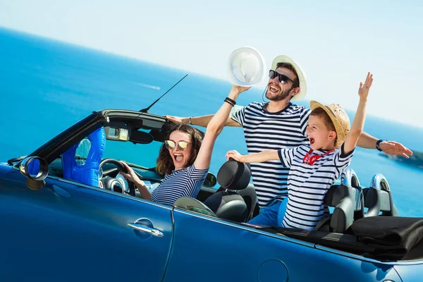 Happy family travel by car to the sea. People having fun in cabriolet. Summer vacation concept